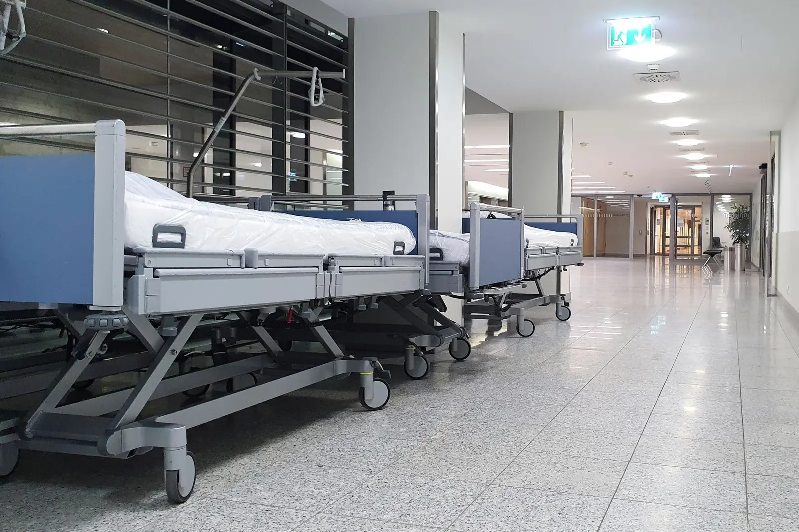 Hospital beds along a modern corridor.